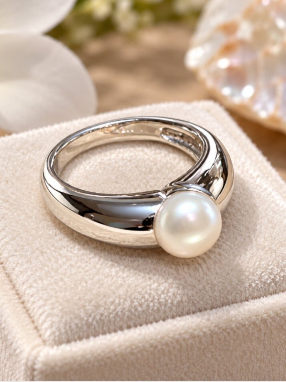 Modern sterling silver band set with a single lustrous white pearl.